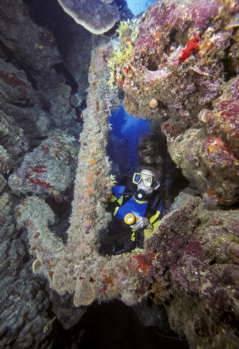 Diver viewing large 16th centry anchor in the wall on Caymann Brac, Cayman Islands, BWI